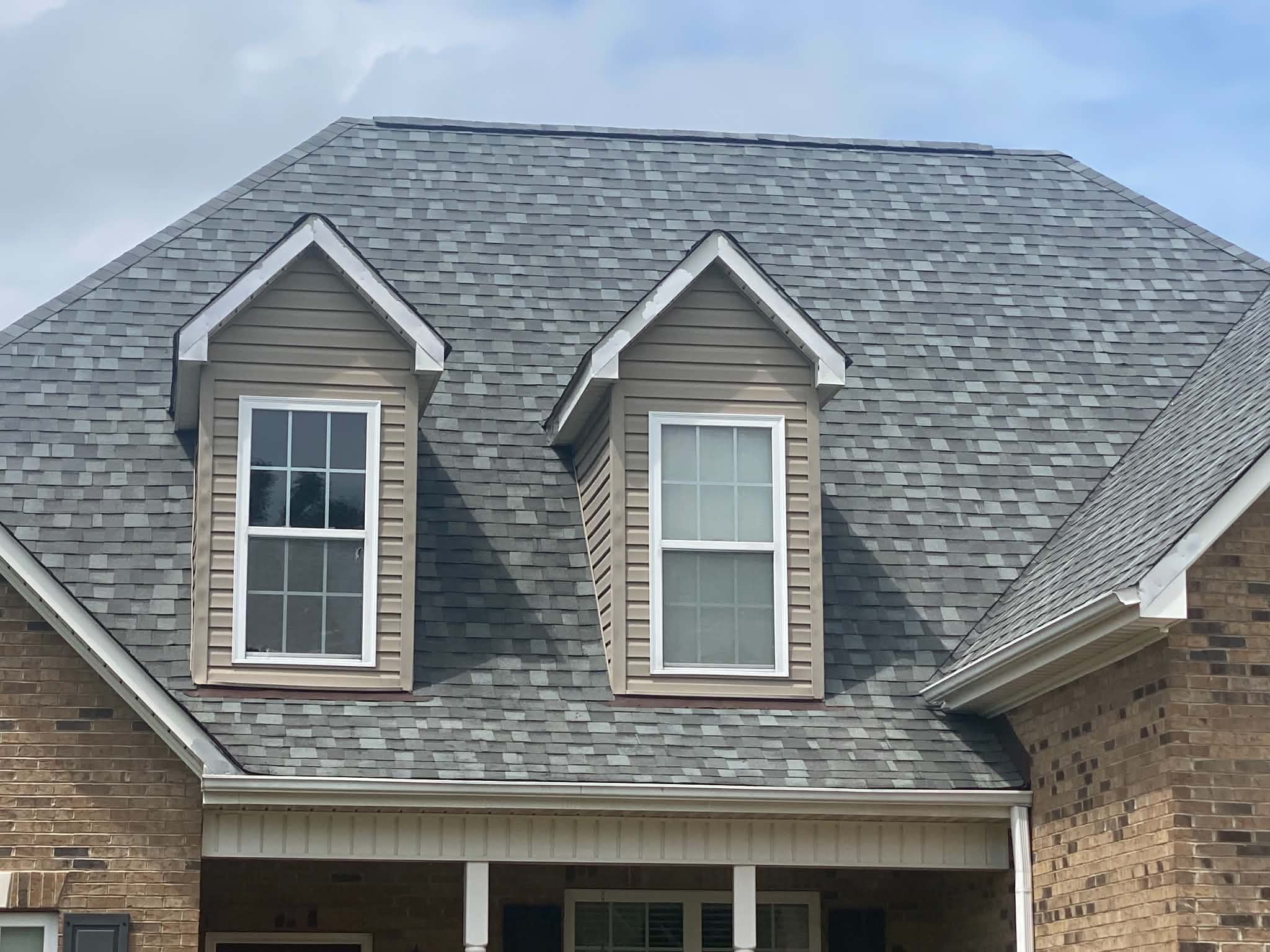 Architectural shingles installed around two dormer windows